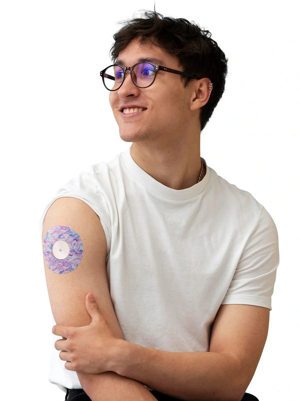 Man wearing a colorful Freestyle Libre 2 adhesive patch on arm, demonstrating secure fit and comfort.