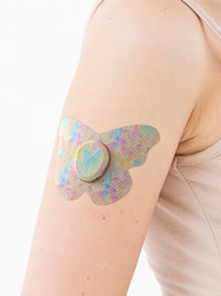 Parche adhesivo para Dexcom G7, forma de mariposa, en el brazo, primer plano