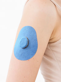 Parche adhesivo para Dexcom G7, forma de gota, en el brazo, primer plano