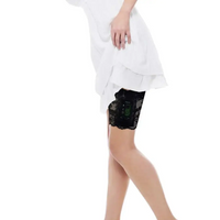 Black lace garter leg band securely holding an insulin pump under a white dress