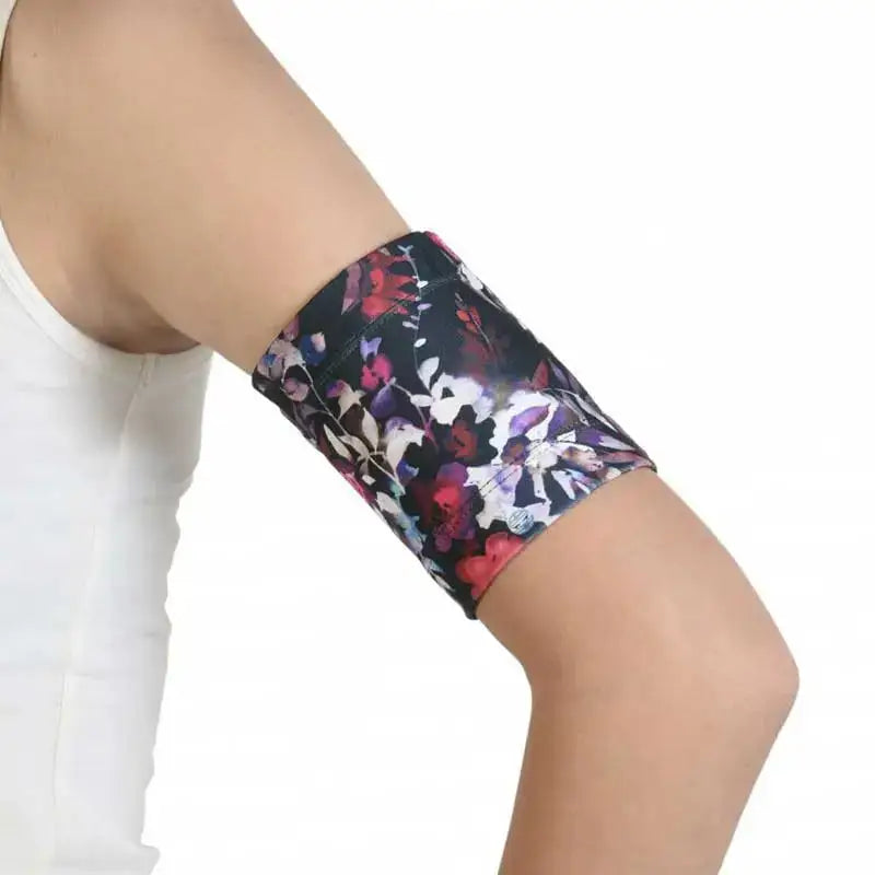 Blood glucose sensor armband with floral design on arm.