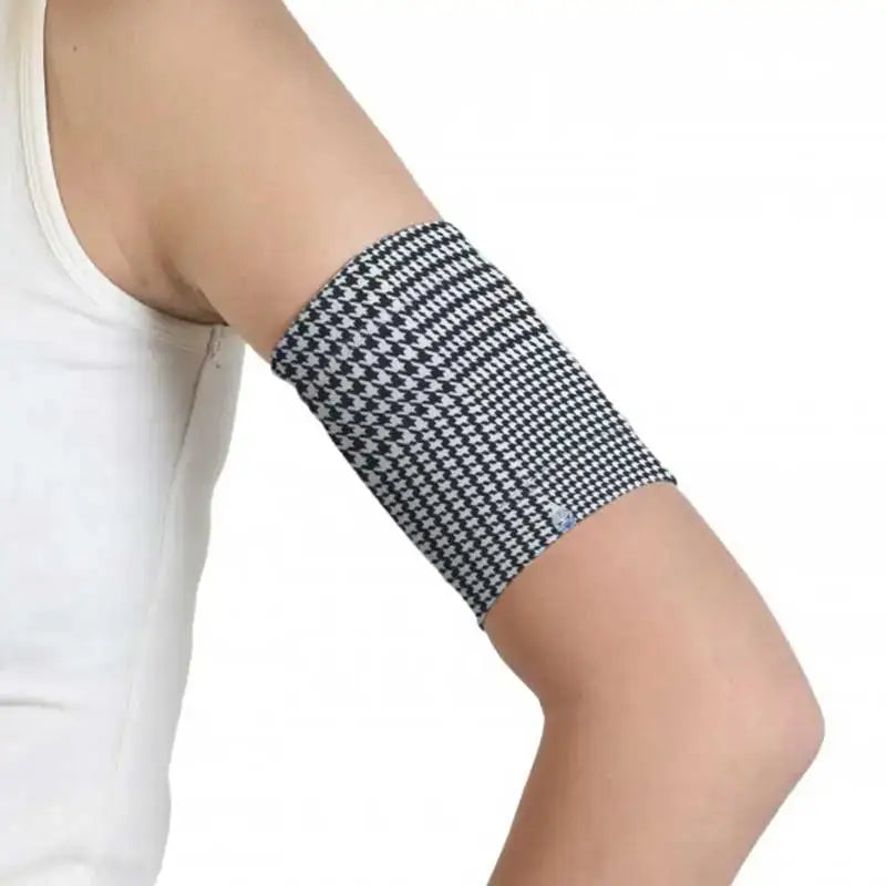 Trendy CGM armband for diabetes with black and white pattern, worn on upper arm.